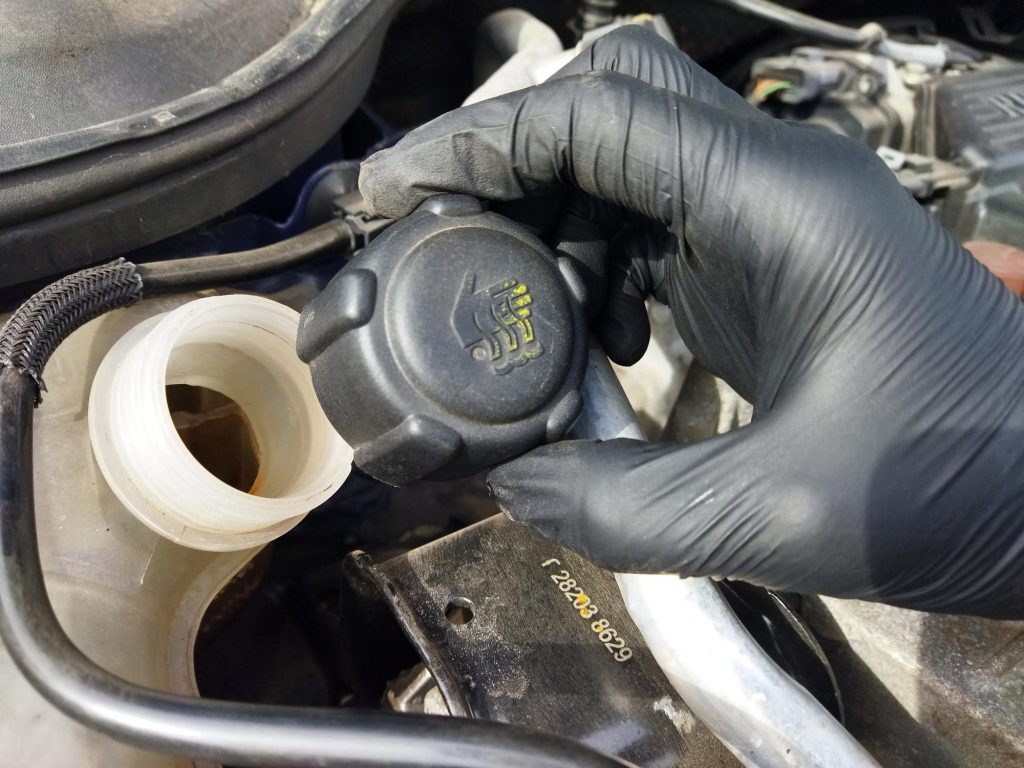 Mechanic checking engine coolant temperature during diagnosis