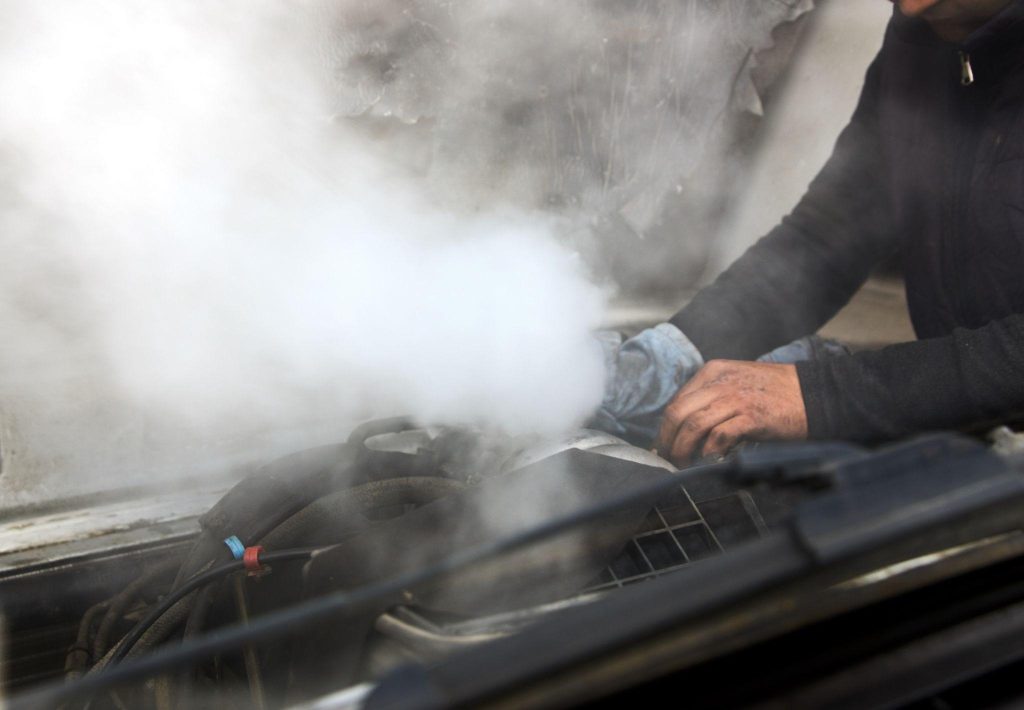 Automotive student diagnosing an overheating engine