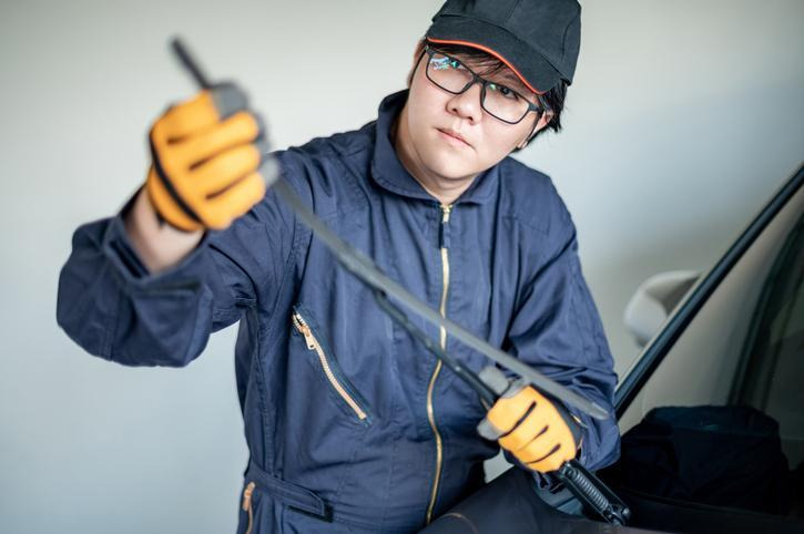 Mechanic inspecting a clogged windshield washer nozzle