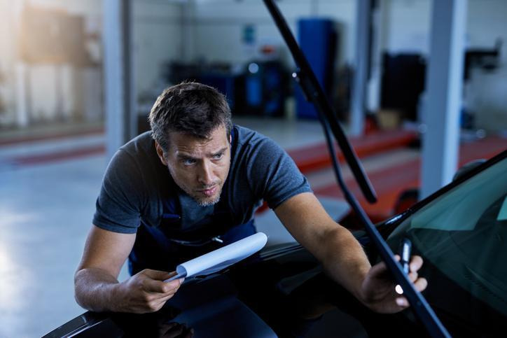 Technician diagnosing a windshield washer not working on a vehicle
