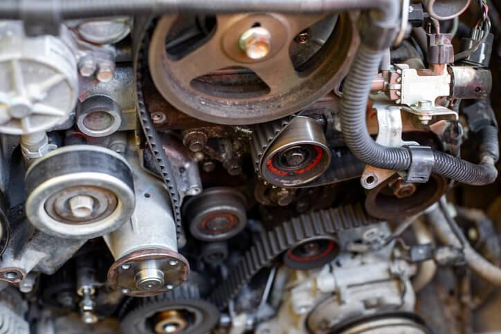 A close-up of a belt tensioner pulley and serpentine belt on an engine