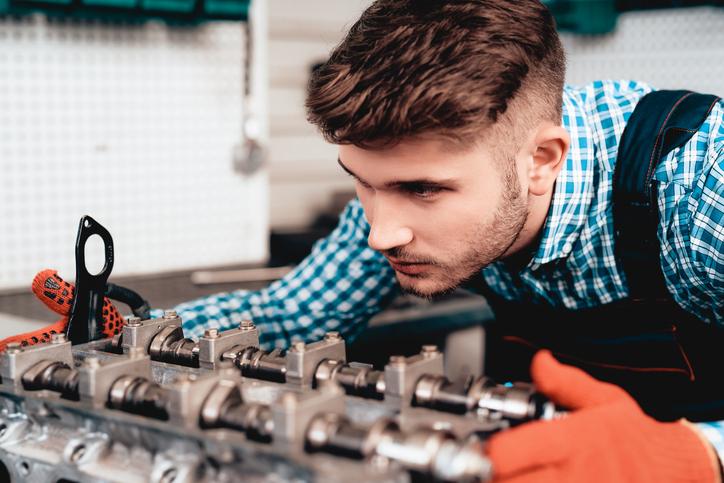 A future technician locating a camshaft sensor during engine diagnosis
