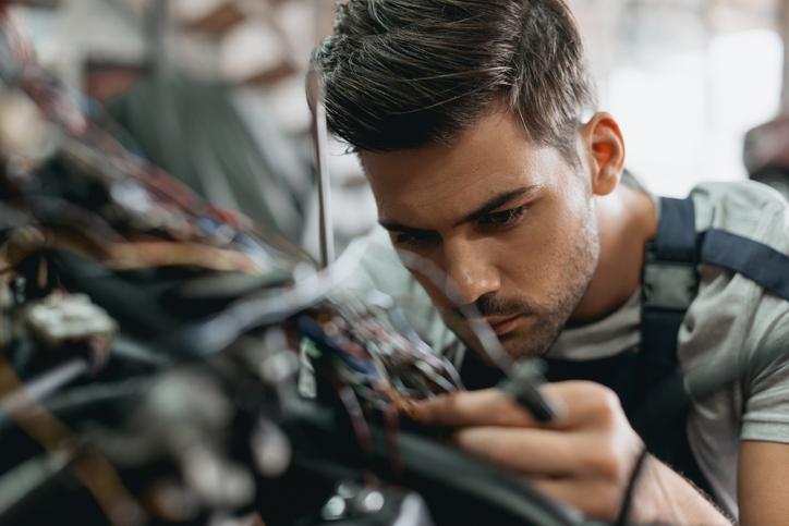 A technician inspecting wiring while investigating a P0340 code