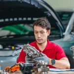 An automotive technician inspecting an engine oil pump assembly during maintenance