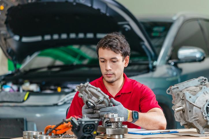 An automotive technician inspecting an engine oil pump assembly during maintenance