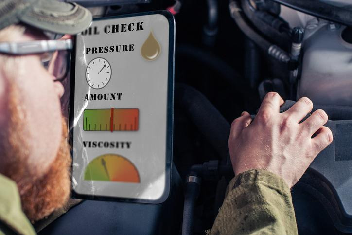 A technician checking engine oil pressure using diagnostic equipment